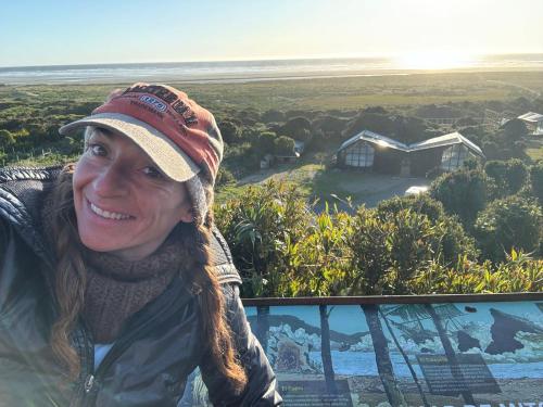 a woman wearing a hat standing in front of a house at Chiloe Loft & Glamp in Chonchi