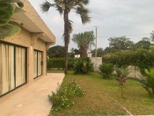 a driveway to a house with a palm tree at Résidence Kanissa in Cap Skirring
