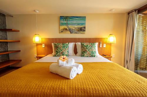 a bedroom with a bed with towels on it at Pousada Lagamar in Praia Vermelha