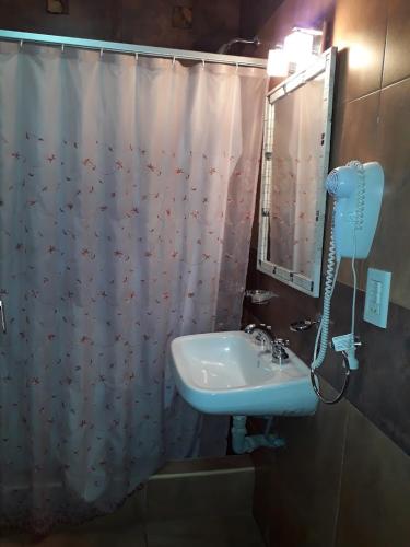 a bathroom with a sink and a shower curtain at Apart Hotel Hualta Picum in San José de Jáchal