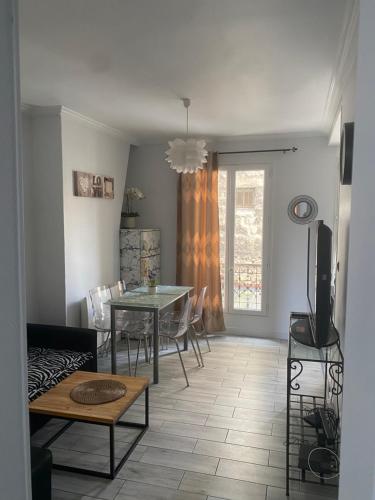 un salon avec une table, des chaises et une télévision dans l'établissement Charmant appartement 2 pieces à 7 mn de paris, à Aubervilliers