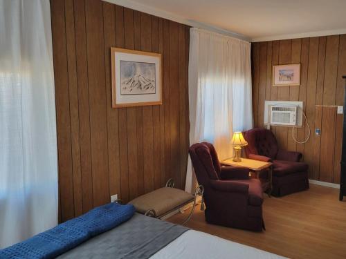 a hotel room with a bed and a chair and a desk at The Link Vintage Motel #1 2bd1ba in Lovelock