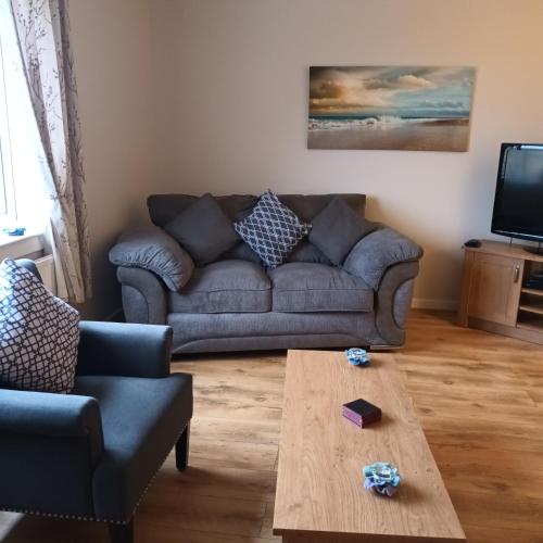 a living room with a couch and a coffee table at Tigh a' Chreagain in Stockinish Island