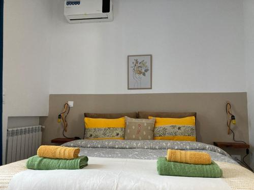a bedroom with a large bed with yellow and green pillows at Azur vue sur mer au coeur de la marsa plage in La Marsa