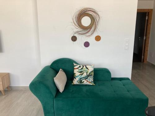 a green couch in a living room with a mirror at Azur vue sur mer au coeur de la marsa plage in La Marsa