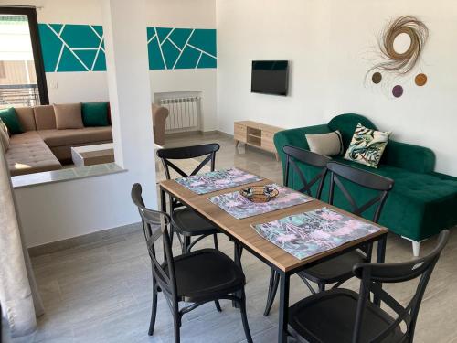 a living room with a table and chairs and a couch at Azur vue sur mer au coeur de la marsa plage in La Marsa