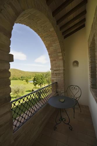 a table and chair on a balcony with a window at Tenuta Del Gallo in Amelia