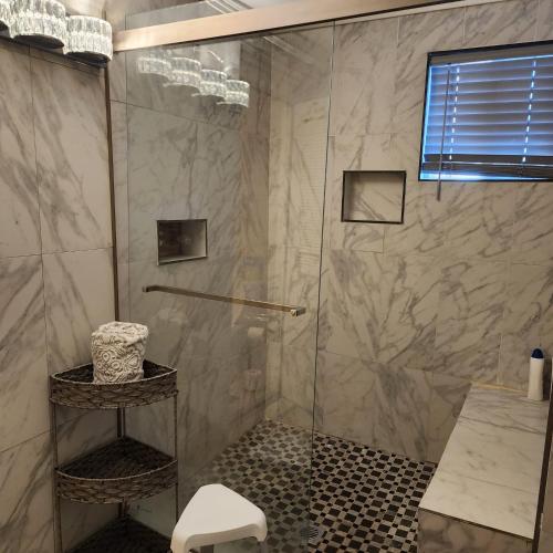 a bathroom with a shower with a glass door at Hilltop Hacienda in San Marcos