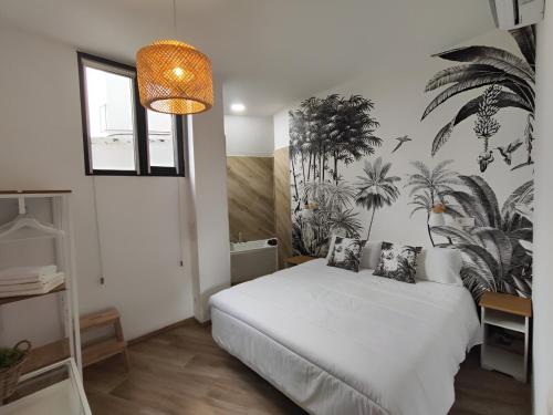 a bedroom with a white bed with plants on the wall at Apartamentos VALDECILLA nuevos in Santander