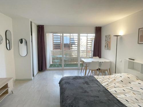 ルルドにあるStudio near train station and sanctuaryのベッドとテーブルと椅子のある寝室