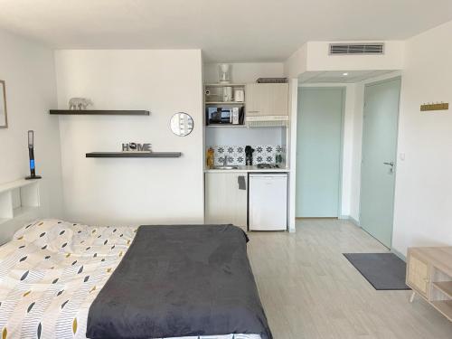 ルルドにあるStudio near train station and sanctuaryのベッドルーム1室(ベッド1台付)、小さなキッチンが備わります。