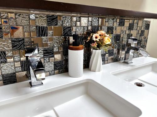 a bathroom with a sink and a tile wall at A bright and tidy room in midtown near subway in Toronto