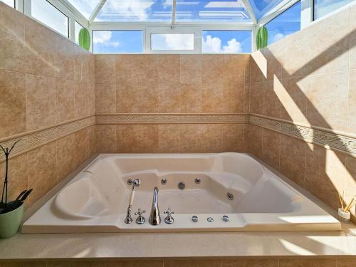a large bath tub in a bathroom with a window at Casa Su eño in Playa Blanca