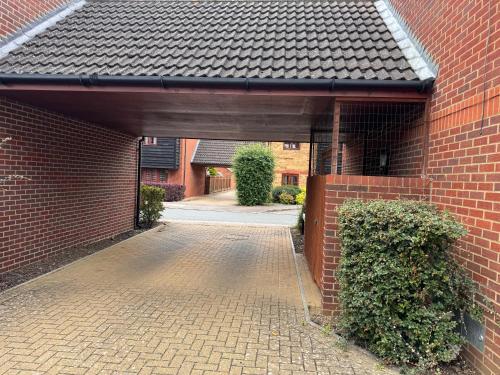 an entrance to a brick building with a brick driveway at Cozy 2bed flat with free parking near Willen Lake in Milton Keynes in Milton Keynes