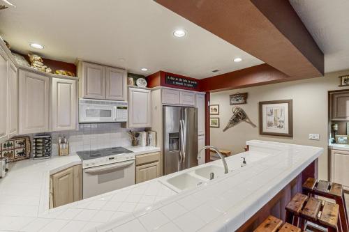 a kitchen with white cabinets and a large white counter top at Lazy on the Lakefront (F205) in Twin Beaches
