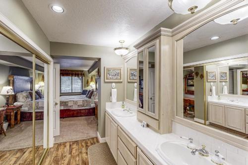 a bathroom with two sinks and a bedroom at Lazy on the Lakefront (F205) in Twin Beaches