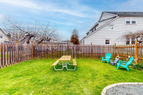 a backyard with a wooden fence and a picnic table and chairs at Mariner's Rest East in Anacortes