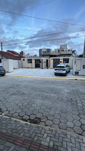 een parkeerplaats met een auto voor een gebouw bij Box 01 a 950 mt do mar, ar- condicionado, TV smart, cozinha privativa in Itapema