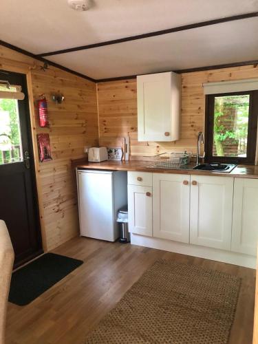 a kitchen with white cabinets and a window at Devoke Water in Elterwater
