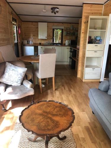 a living room with a table and a kitchen at Devoke Water in Elterwater