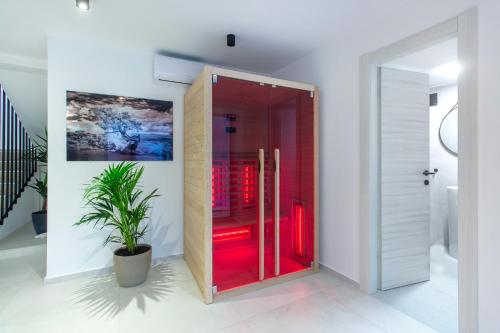 a glass door in a room with a plant at Seafront Villa Kupinica with heated Pool in Vinišće