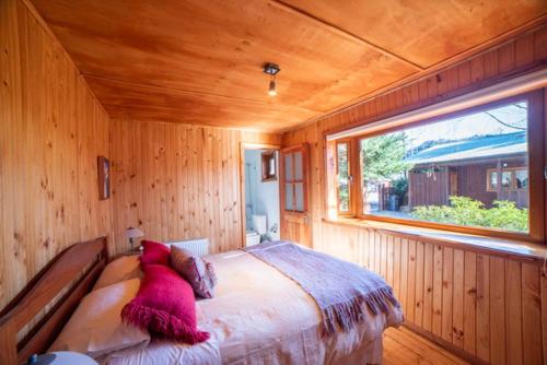 a bedroom with a large bed with a window at Cabañas Neyén in Malalcahuello