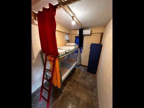 a small room with two bunk beds and a ladder at Gili La Boheme in Gili Trawangan