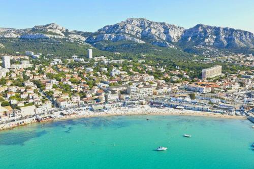 une vue aérienne d'une plage avec des bateaux dans l'eau dans l'établissement Maisonnette Pointe Rouge, à Marseille