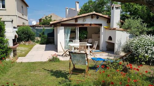 une maison avec une table et des chaises dans une cour dans l'établissement Maisonnette Pointe Rouge, à Marseille