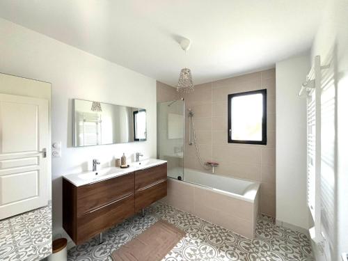 a bathroom with a tub and a sink and a shower at Villa entre Terre et Mer in Hauteville-sur-Mer