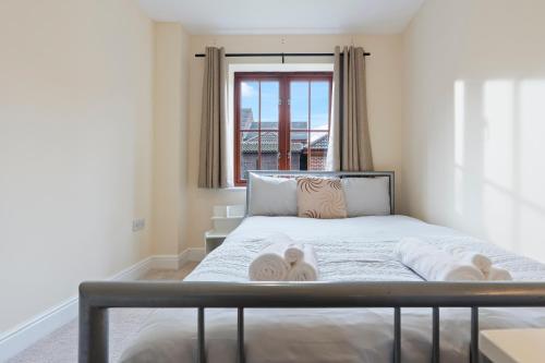 a bedroom with a bed with towels on it at Cozy 2bed flat with free parking near Willen Lake in Milton Keynes in Milton Keynes