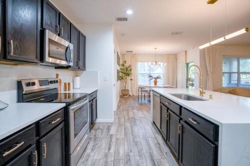 a kitchen with black cabinets and white counter tops at Cozy home near MCO in Kissimmee