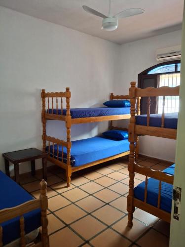 a room with three bunk beds in it at Casa no Guaraú - Peruíbe in Peruíbe