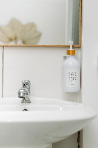 a bottle of hand soap sitting on a bathroom sink at Hotel VillaFlores in Quesada