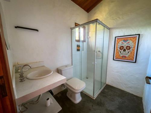 イビコアラにあるSítio Serra da Águiaのトイレとガラスのシャワー付きのバスルーム