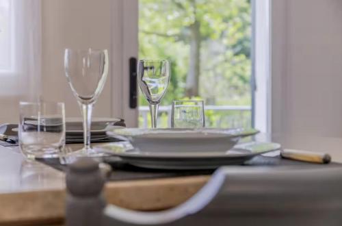 a table with wine glasses and plates on it at Elegante Appartamento con Vista - Colli Euganei in Teolo