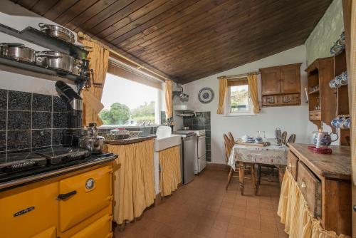 Una cocina con electrodomésticos amarillos y una mesa en ella. en Penrhyn, en Goodwick