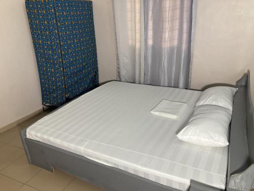 a bed with white sheets and pillows in a room at Residence MaryHouse - Free Breakfast and Taxi From Airport in Cotonou