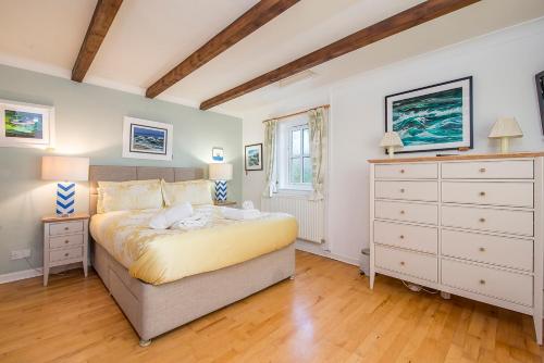 a bedroom with a large bed and a dresser at Willowcot Cottage in Haverfordwest