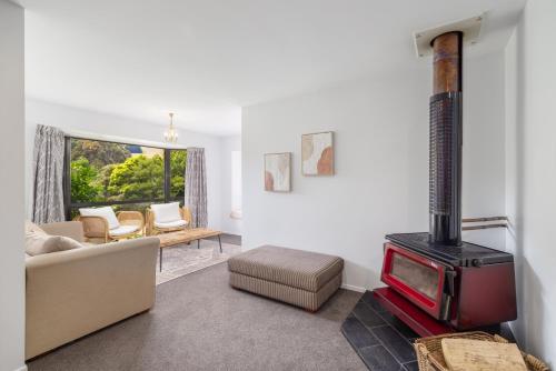 a living room with a fireplace and a couch at Forest View - Spacious & private full home retreat in Little River
