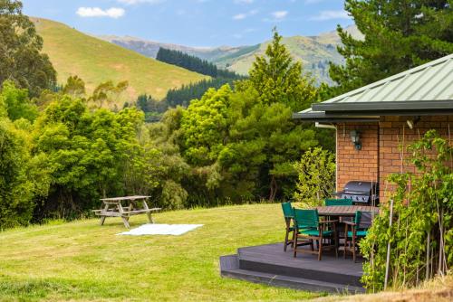a cabin with a table and chairs and a grill at Forest View - Spacious & private full home retreat in Little River