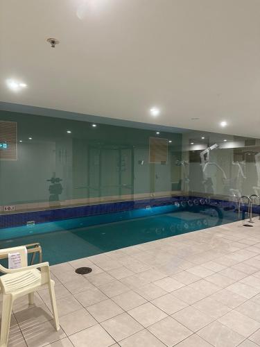 a large swimming pool with a chair and a table and a chair at North Sydney apartment with free parking in Sydney