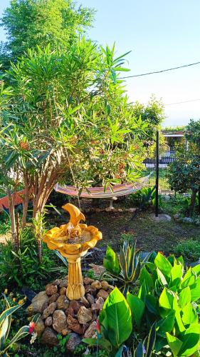 a yellow fountain in the middle of a garden at Traditional house at Pelion seaside in Agria