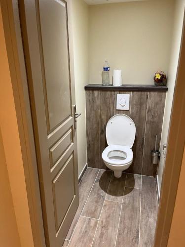 La salle de bains est pourvue de toilettes et d'un mur en bois. dans l'établissement Maison des mûriers, au Luc