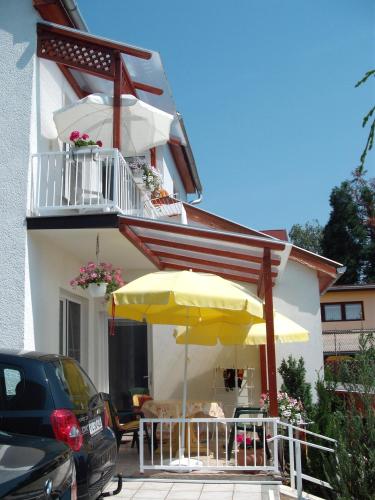 a patio with an umbrella and a table and chairs at Apart Hévízi Ház in Hévíz