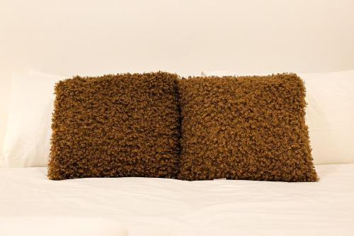 a brown pillow sitting on top of a bed at StayAU Convenient Apartment with Patio in Box Hill in Box Hill