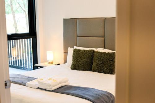 a bedroom with a large bed with towels on it at StayAU Convenient Apartment with Patio in Box Hill in Box Hill