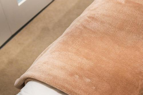 a close up of the sleeve of a brown coat at StayAU Convenient Apartment with Patio in Box Hill in Box Hill