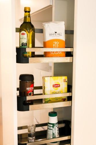 a pantry with food and drinks on shelves at StayAU Convenient Apartment with Patio in Box Hill in Box Hill