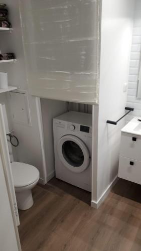 une salle de bain avec machine à laver et toilettes dans l'établissement Breeze in the city, à Lyon